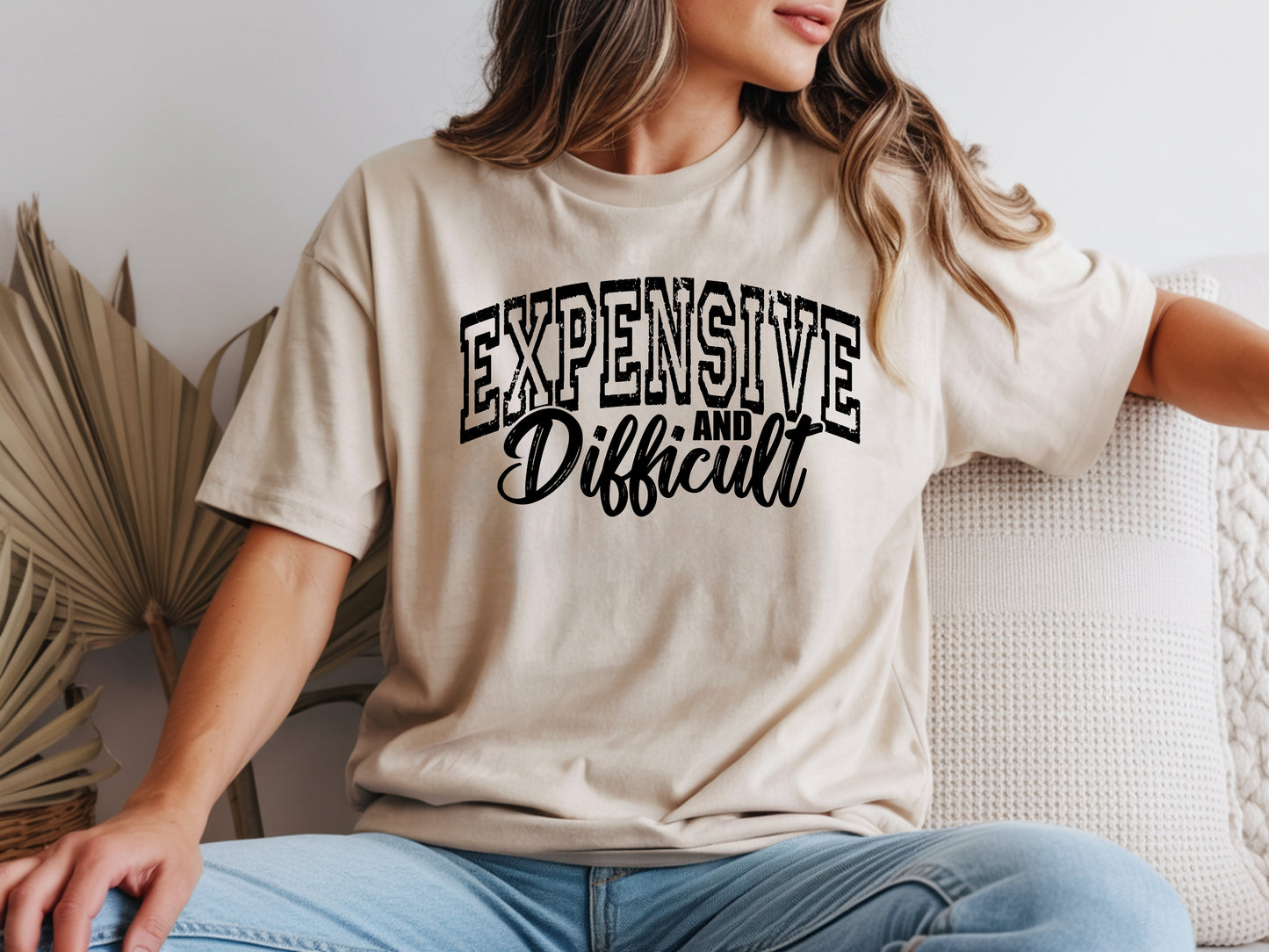 Person wearing beige unisex expensive and difficult shirt with bold “Expensive and Difficult” statement graphic