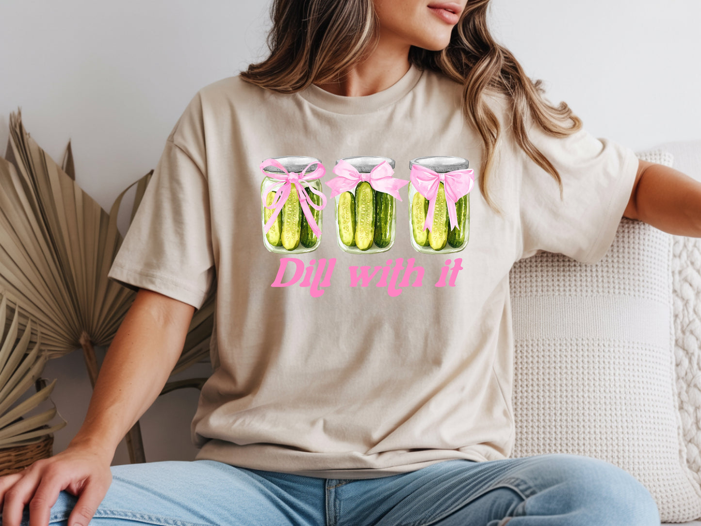 Person wearing beige unisex pickle t shirt with “Dill With It” quote and cute pickle jar design