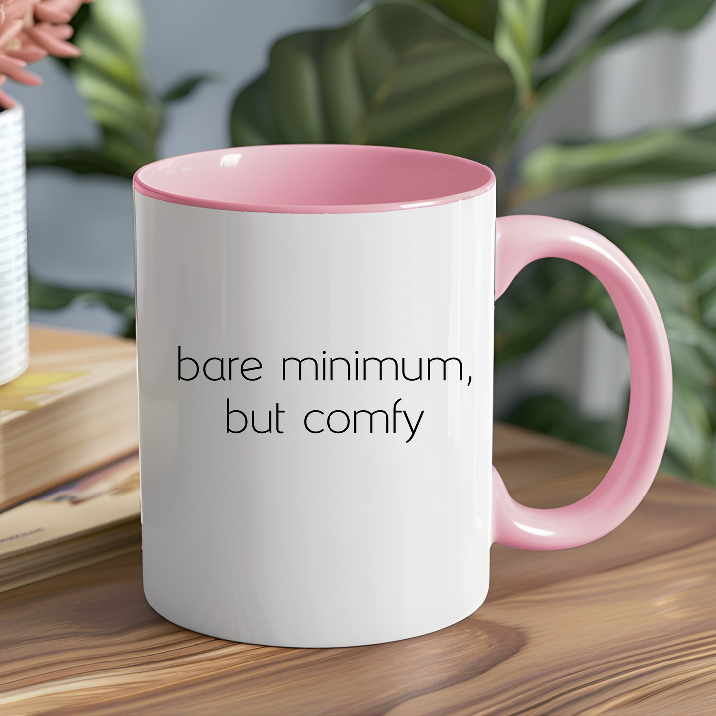 Cute mug that is white but has a pink handle and pink inside with 'bare minimum, but comfy' text on the front.