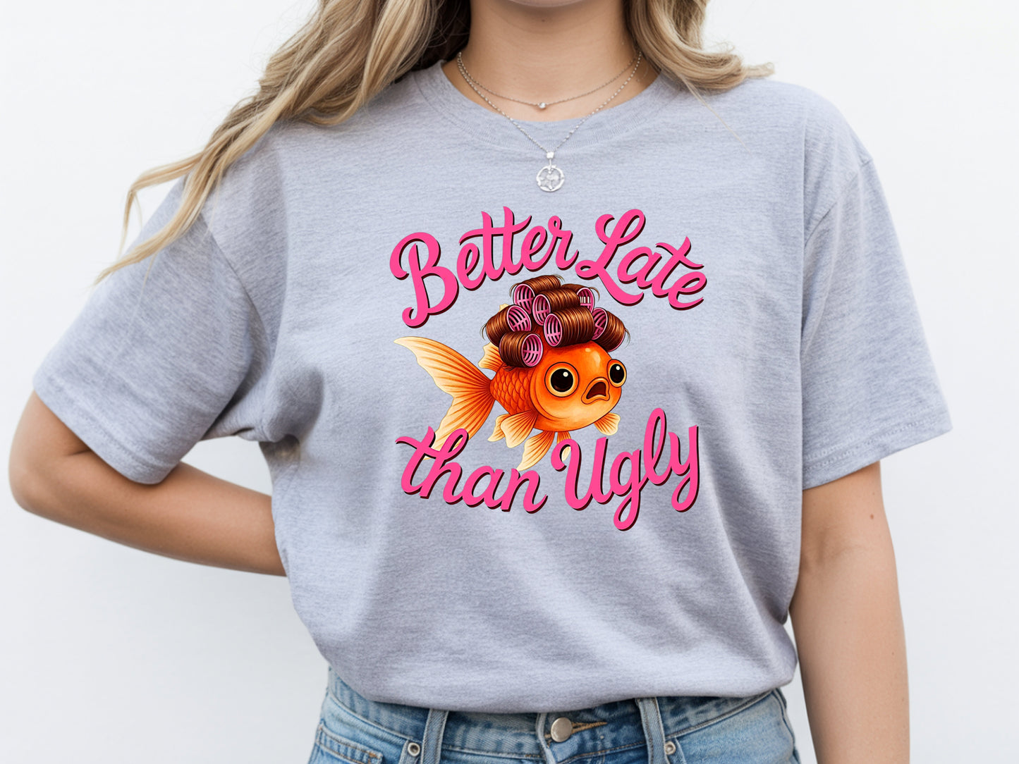 Person wearing grey unisex cute fish t shirt with “Better Late Than Ugly” sarcastic quote and glam goldfish design
