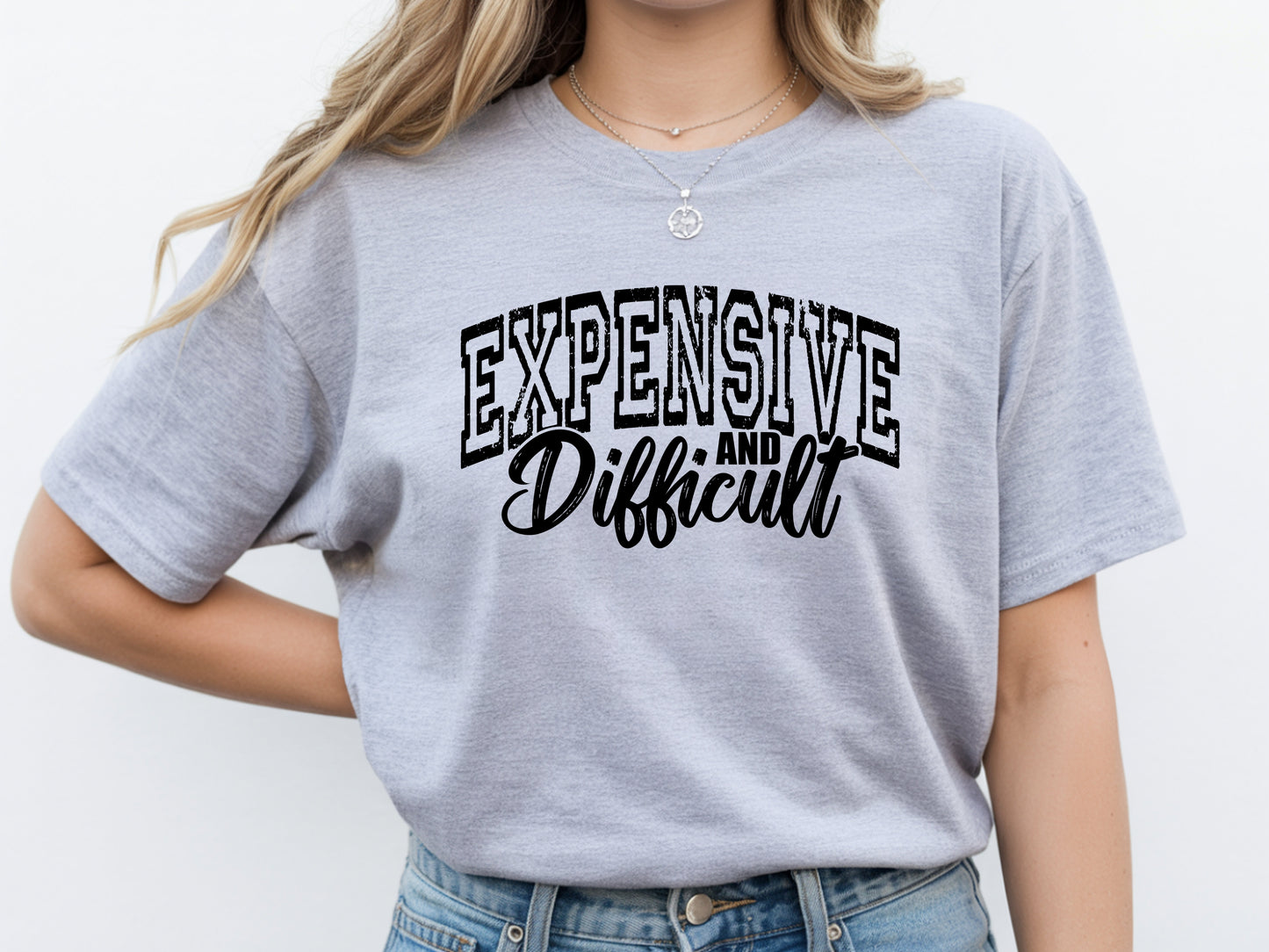 Person wearing grey unisex expensive and difficult shirt with bold “Expensive and Difficult” statement graphic