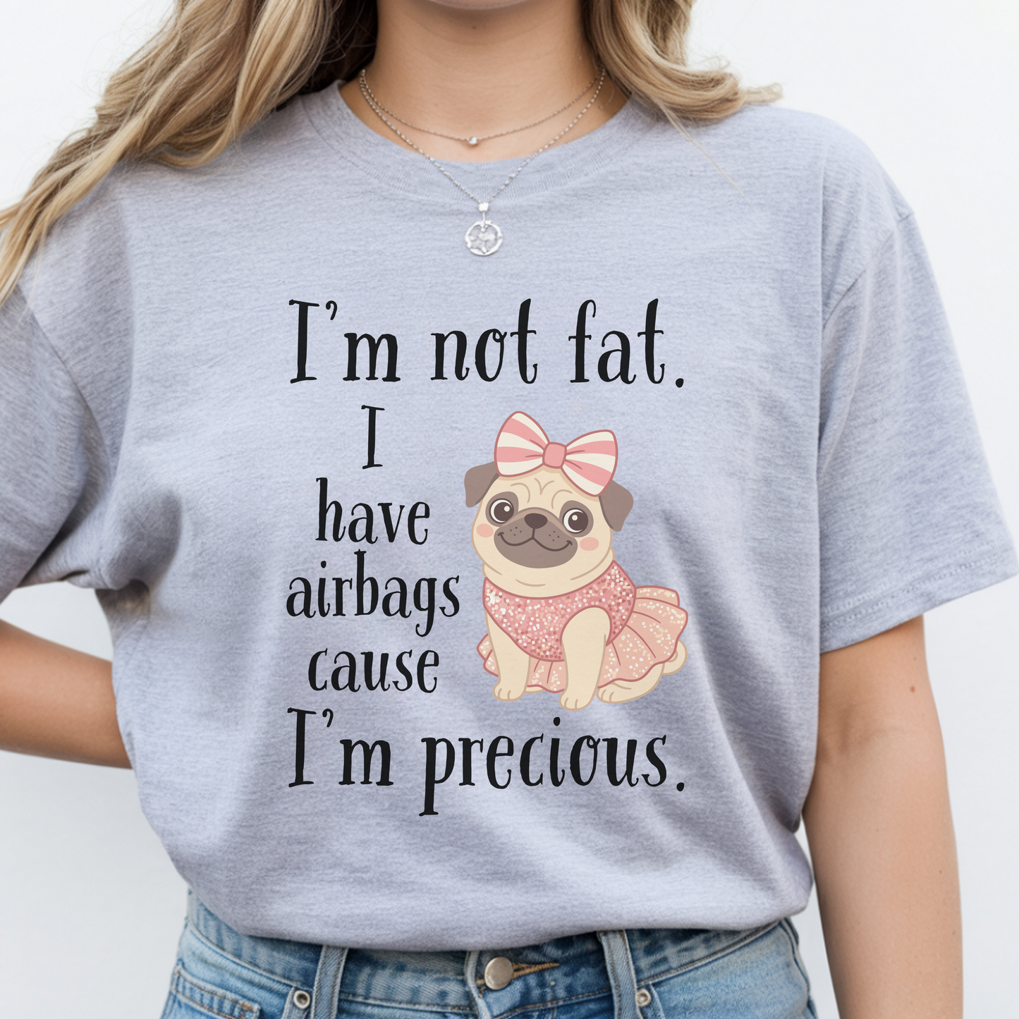 Woman wearing grey funny graphic tee featuring the “I’m Not Fat, I Have Airbags Cause I’m Precious” quote.