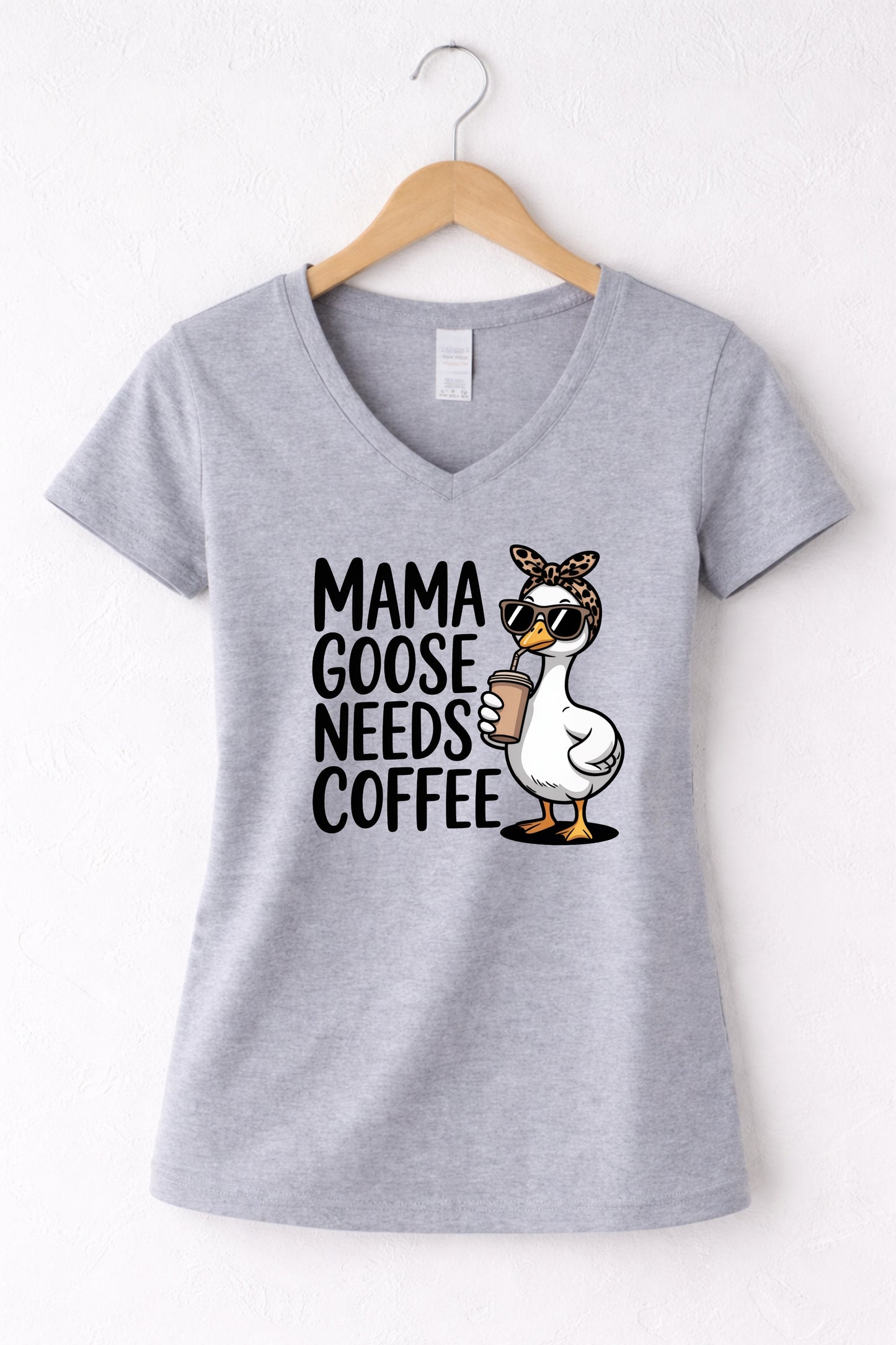 Mama needs coffee shirt with cute "Mama goose needs coffee" text and goose graphic on a grey women's V-neck shirt.