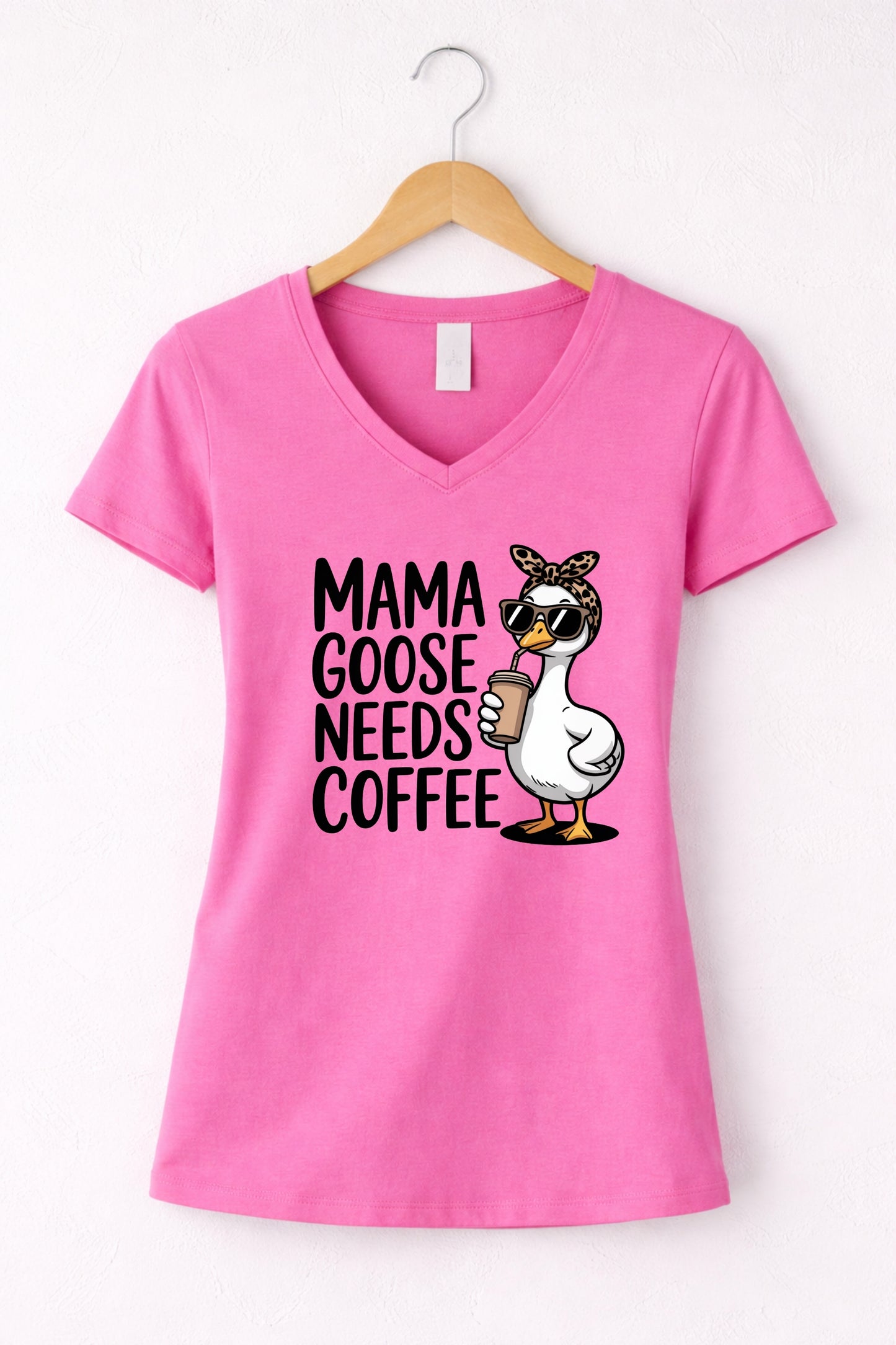 Mama needs coffee shirt with cute "Mama goose needs coffee" text and goose graphic on a pink women's V-neck shirt.