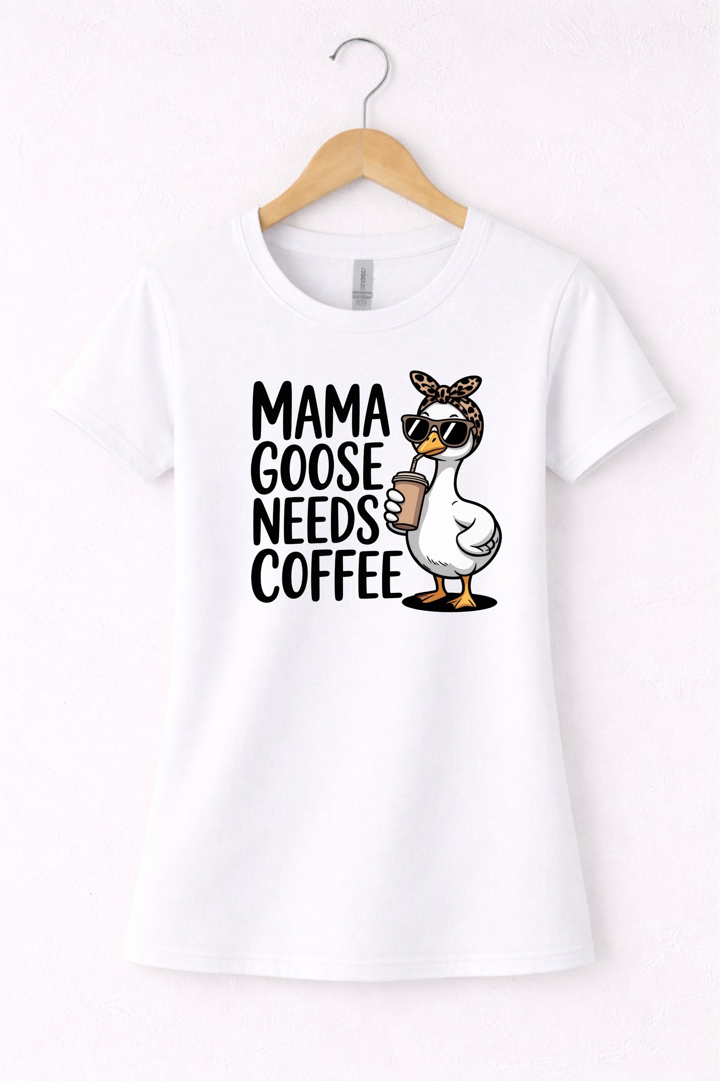 Mama needs coffee shirt with cute "Mama goose needs coffee" text and goose graphic on a white women's crewneck shirt.