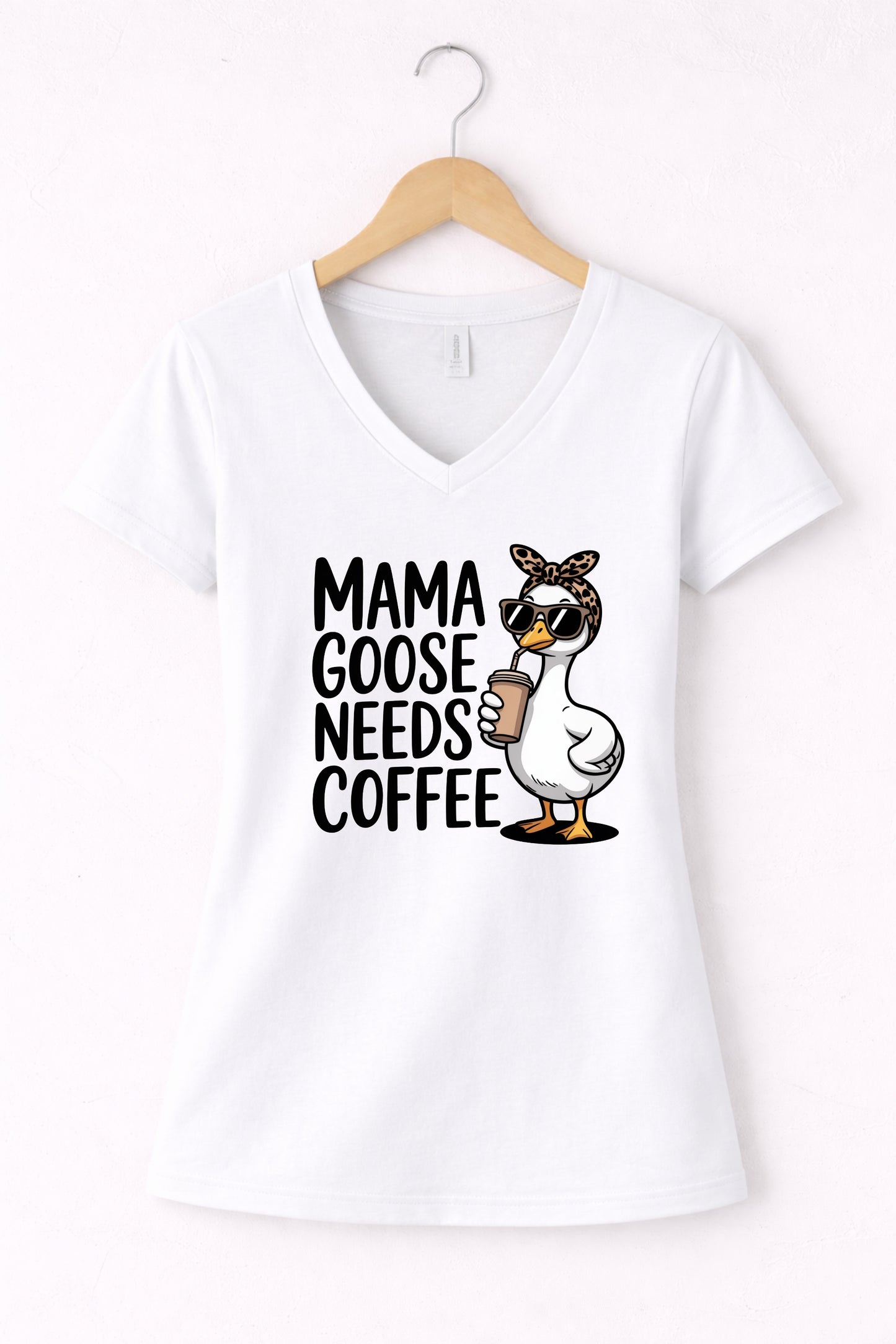 Mama needs coffee shirt with cute "Mama goose needs coffee" text and goose graphic on a white women's V-neck shirt.