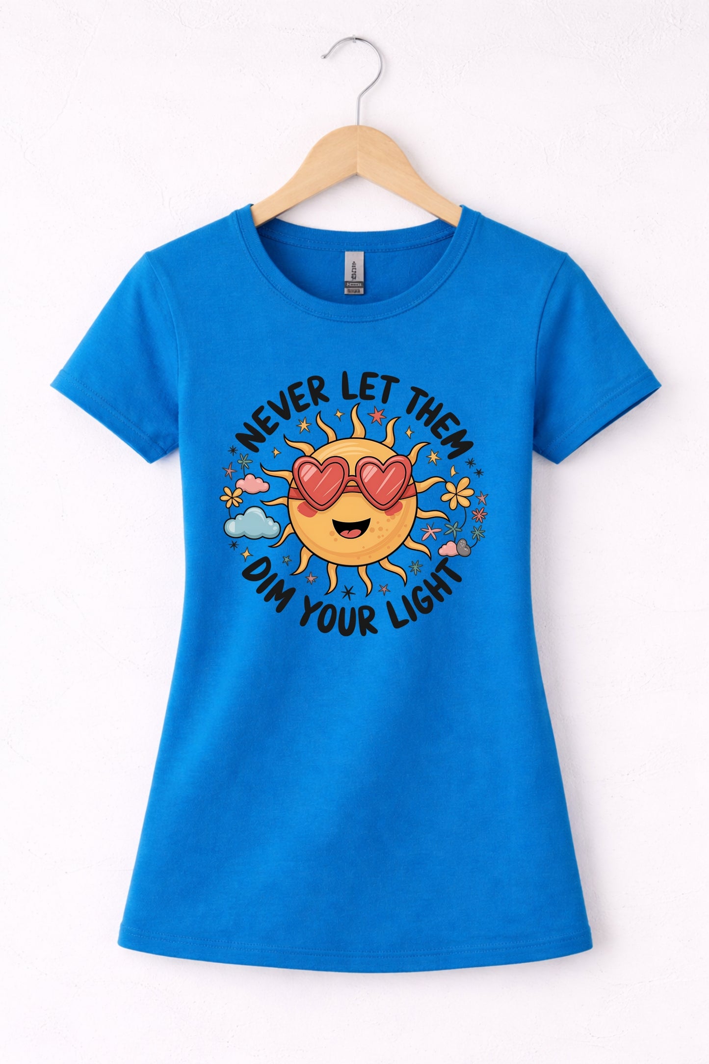 Never let them dim your light shirt with a cute sun graphic and "Never let them dim your light" text on a blue women's crewneck shirt.