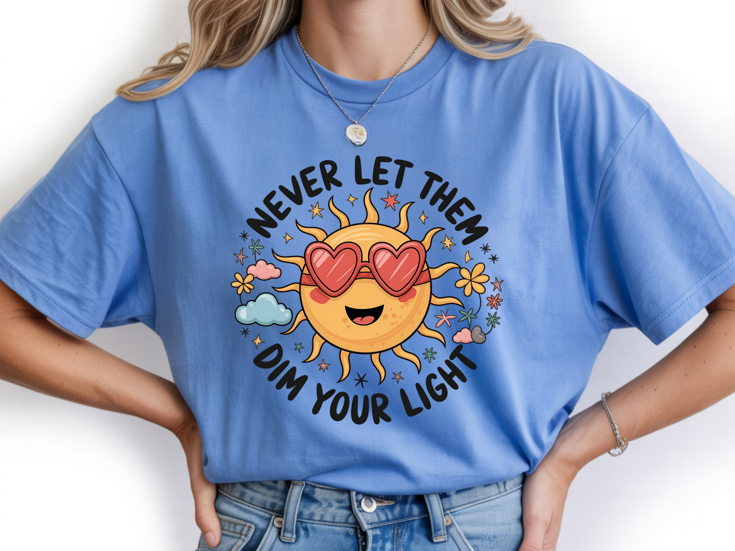 Never let them dim your light shirt with a cute sun graphic and "Never let them dim your light" text on a blue unisex shirt.