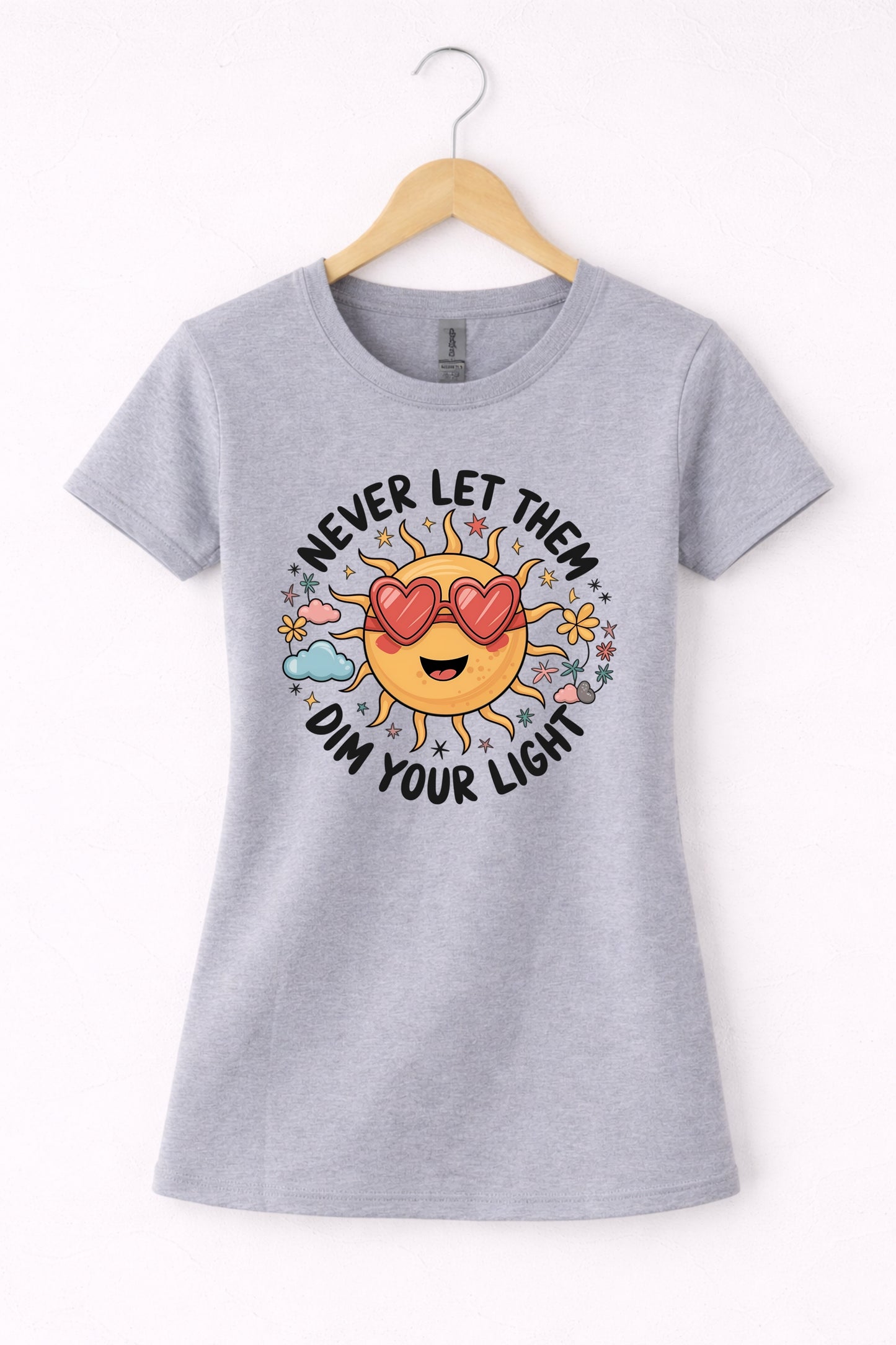 Never let them dim your light shirt with a cute sun graphic and "Never let them dim your light" text on a grey women's crewneck shirt.