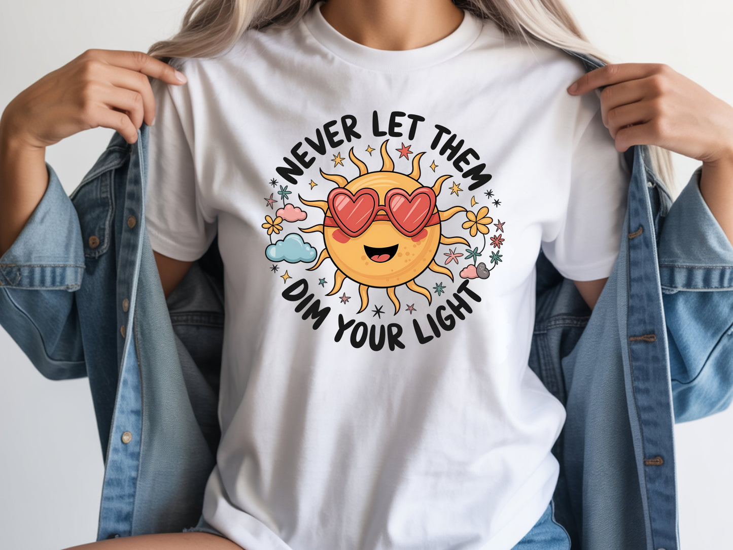 Never let them dim your light shirt with a cute sun graphic and "Never let them dim your light" text on a white unisex shirt.