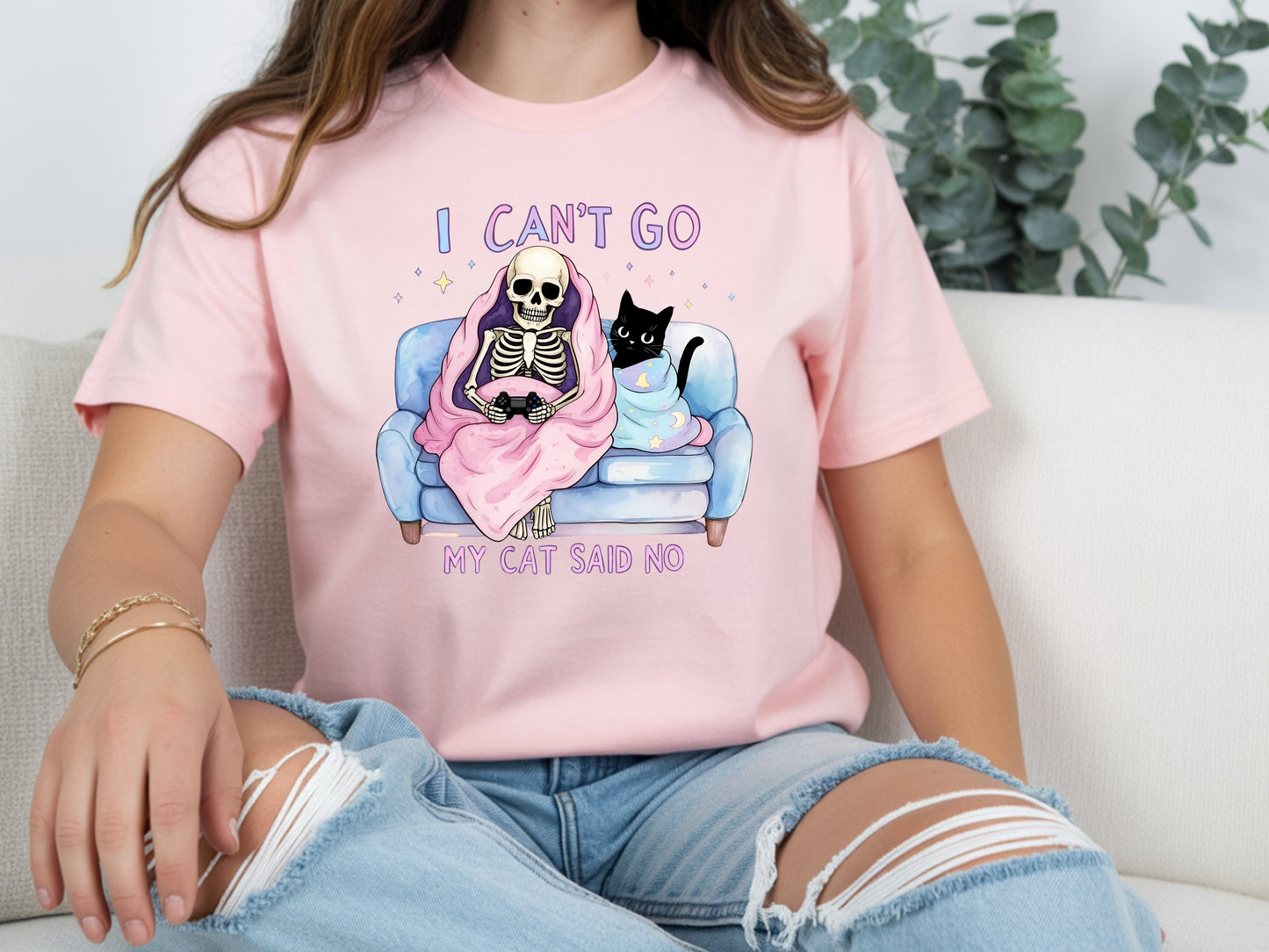 Person wearing pink unisex cat lover graphic tee with “I Can’t Go My Cat Said No” quote and skeleton cat design