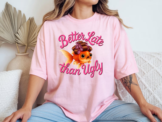 Person wearing pink unisex cute fish t shirt with “Better Late Than Ugly” sarcastic quote and glam goldfish design
