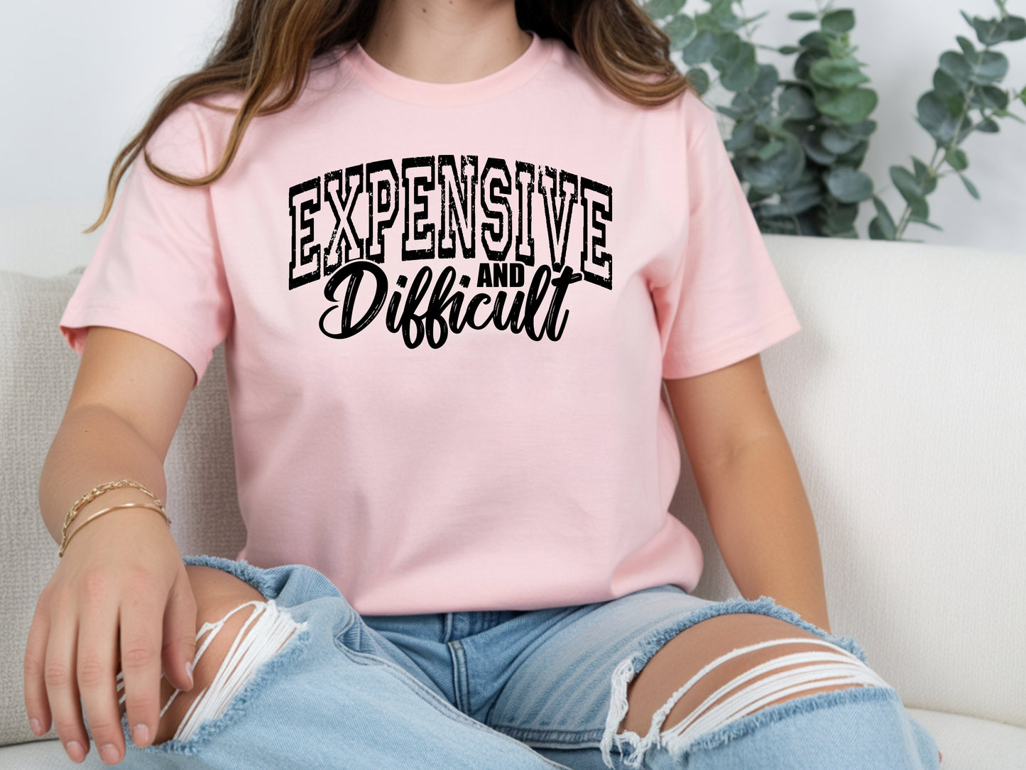 Person wearing pink unisex expensive and difficult shirt with bold “Expensive and Difficult” statement graphic