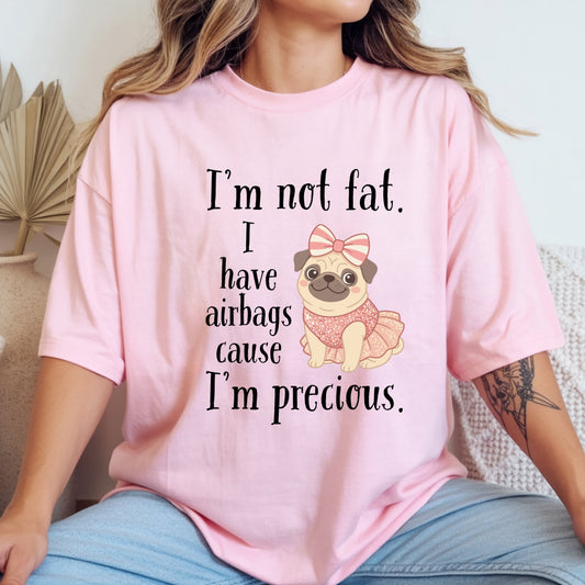 Woman wearing pink funny graphic tee featuring the “I’m Not Fat, I Have Airbags Cause I’m Precious” quote.