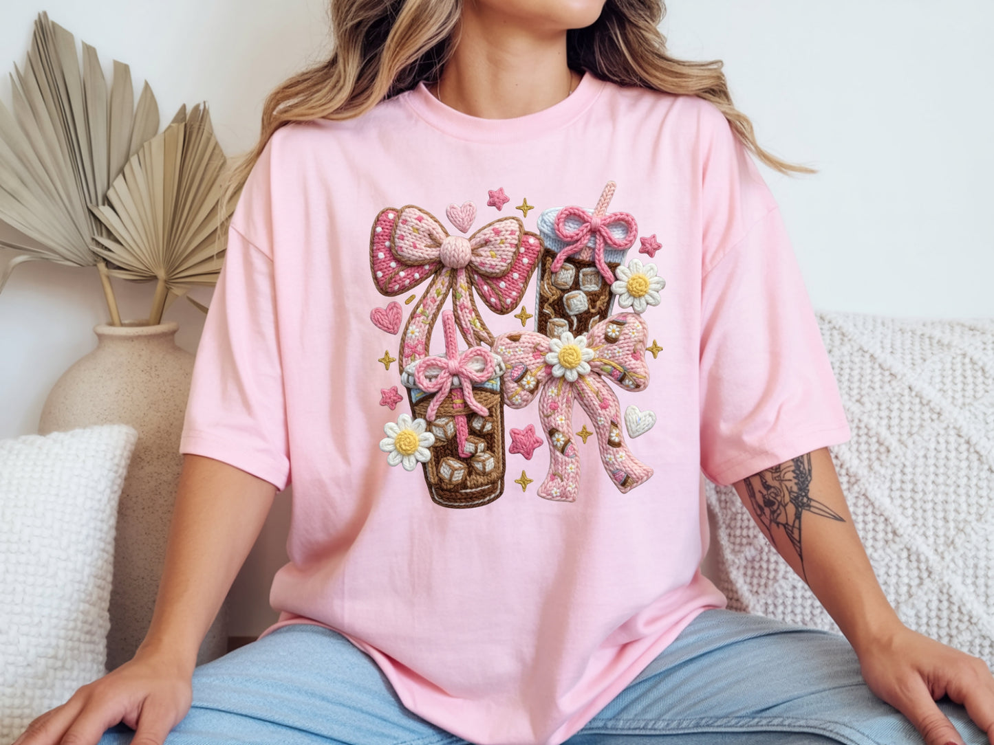 Woman wearing pink iced coffee t shirt with faux yarn style bow design