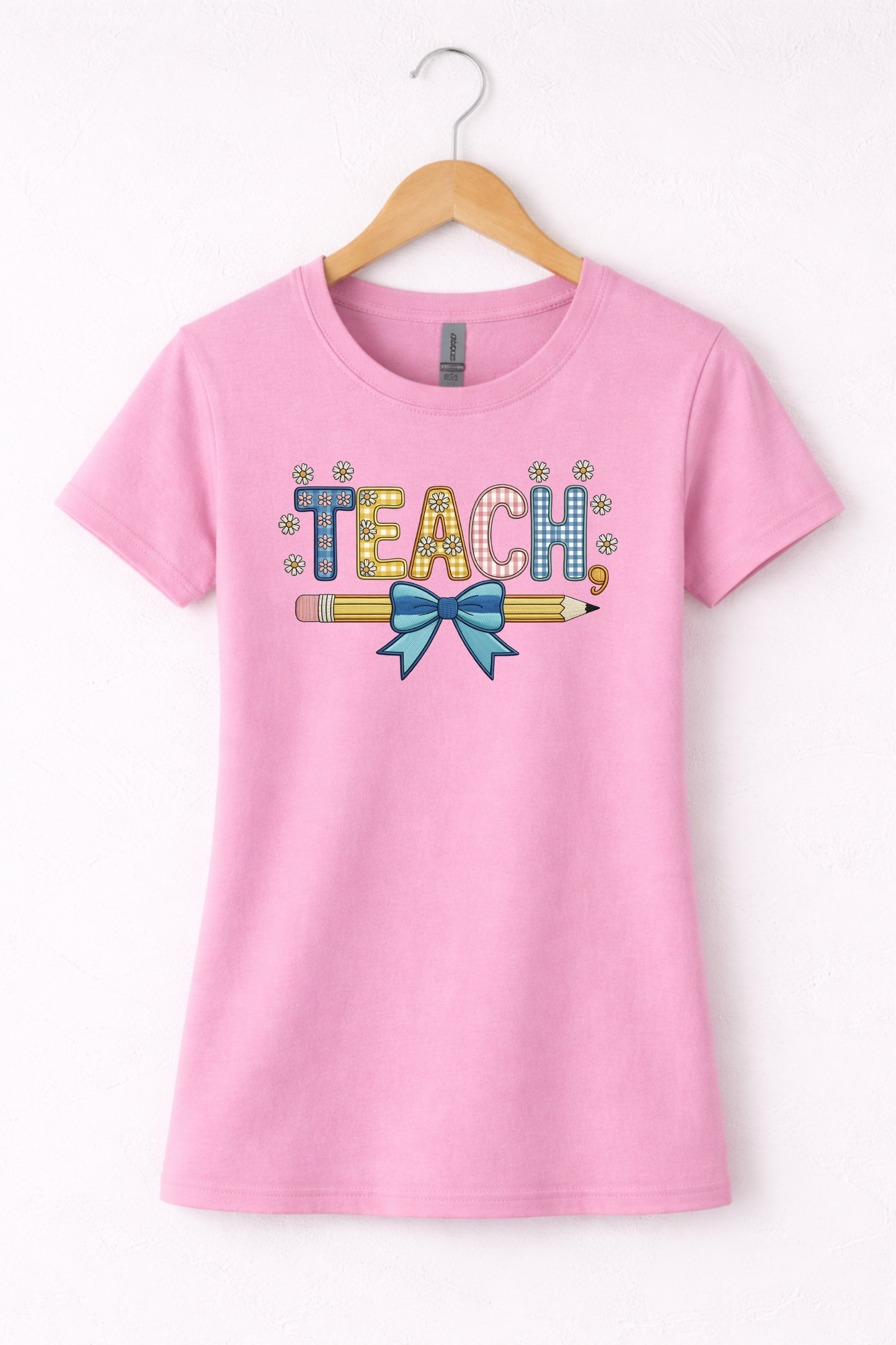 Teacher shirt for women with a cute pencil with blue bow graphic and "Teach" text on a pink women's crewneck tshirt. 