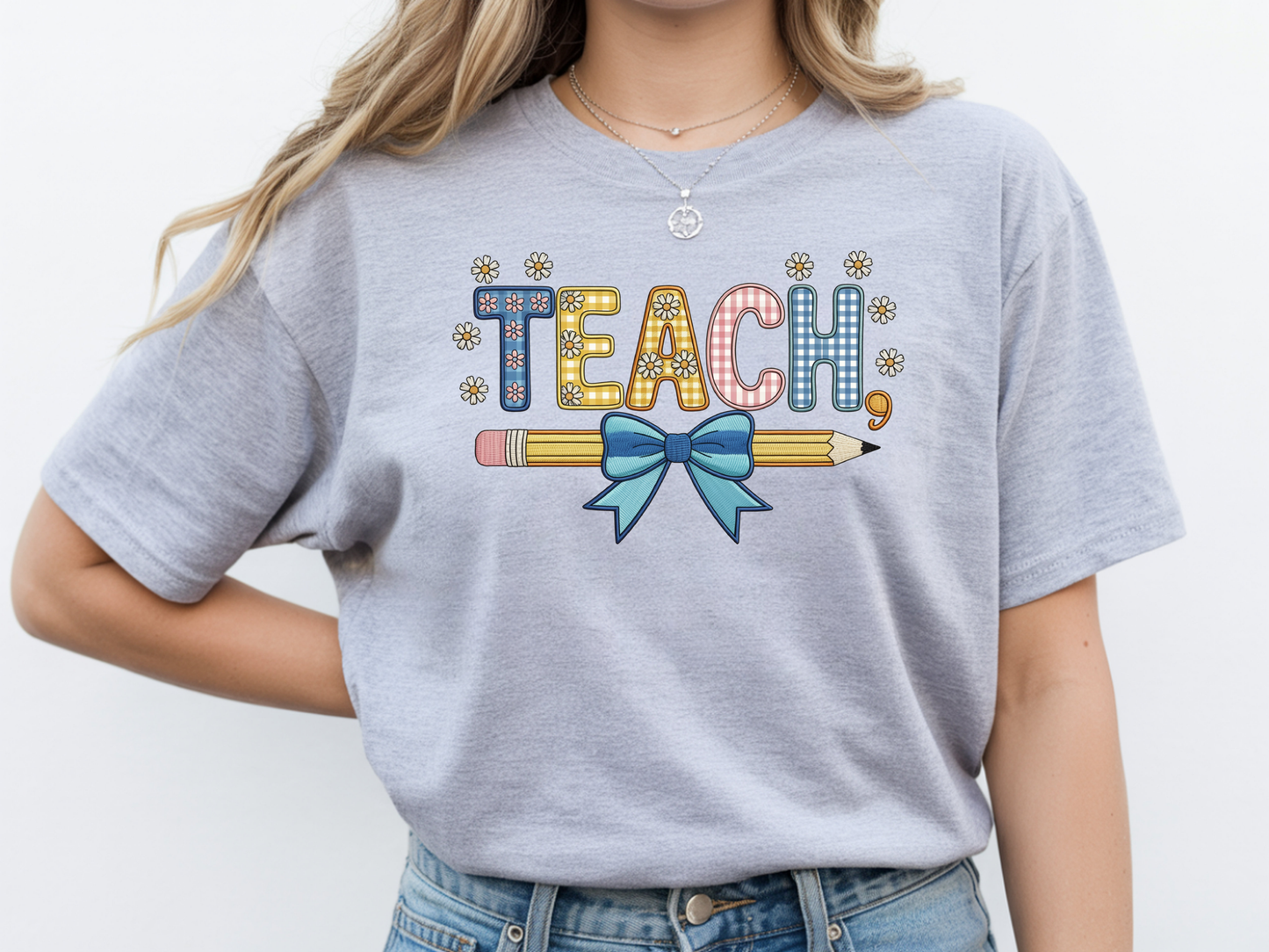 Teacher shirt for women with a cute pencil with blue bow graphic and "Teach" text on a grey unisex tee.