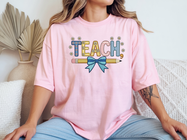 Teacher shirt for women with a cute pencil with blue bow graphic and "Teach" text on a pink unisex tee.