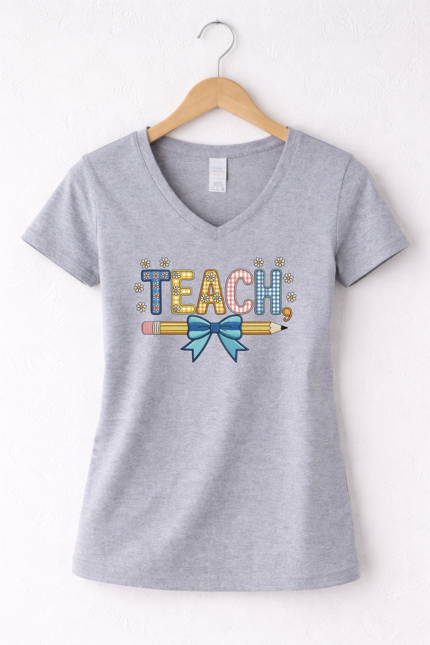 Teacher shirt for women with a cute pencil with blue bow graphic and "Teach" text on a grey women's v-neck tshirt. 