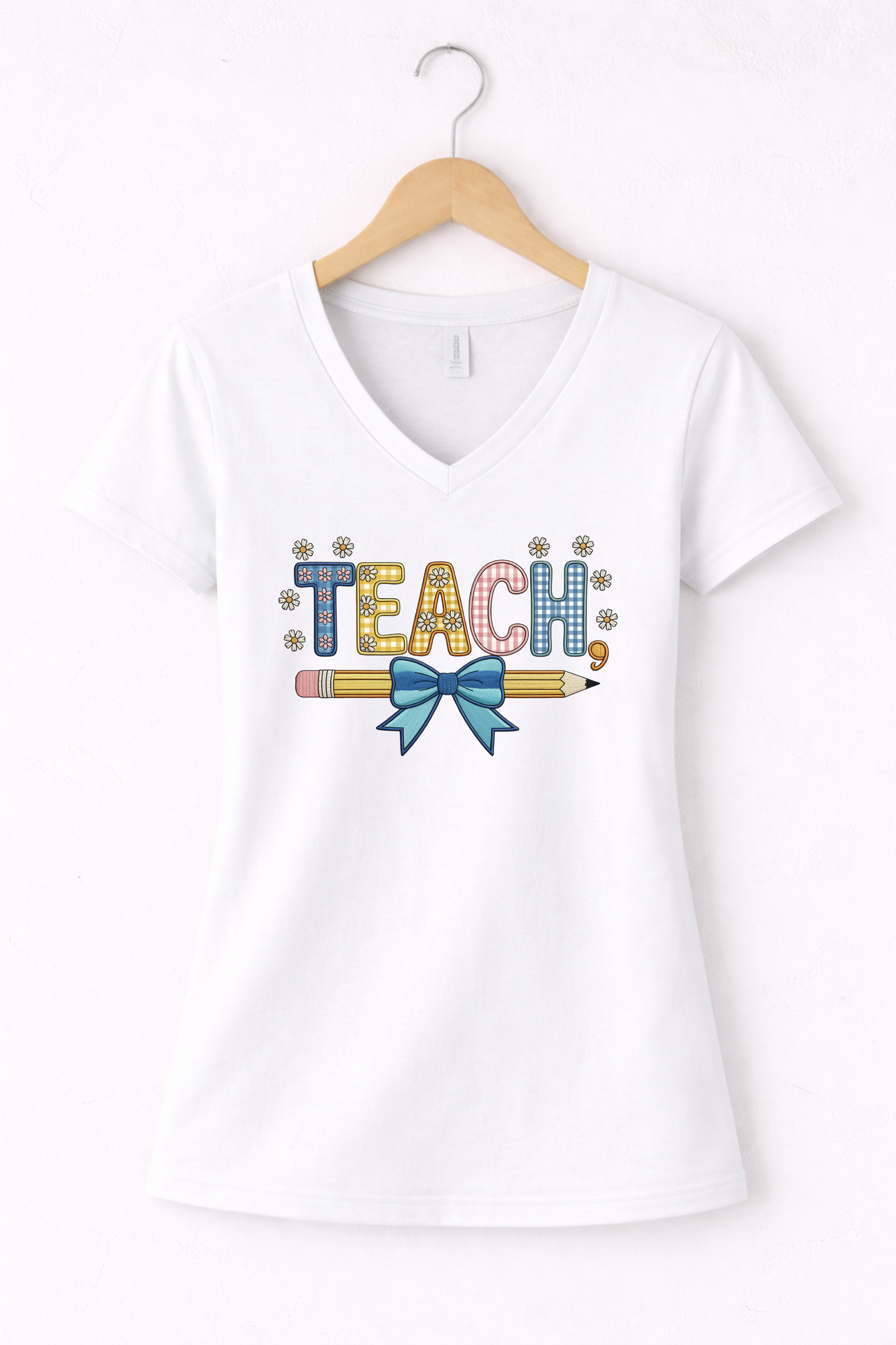 Teacher shirt for women with a cute pencil with blue bow graphic and "Teach" text on a white women's v-neck tshirt. 