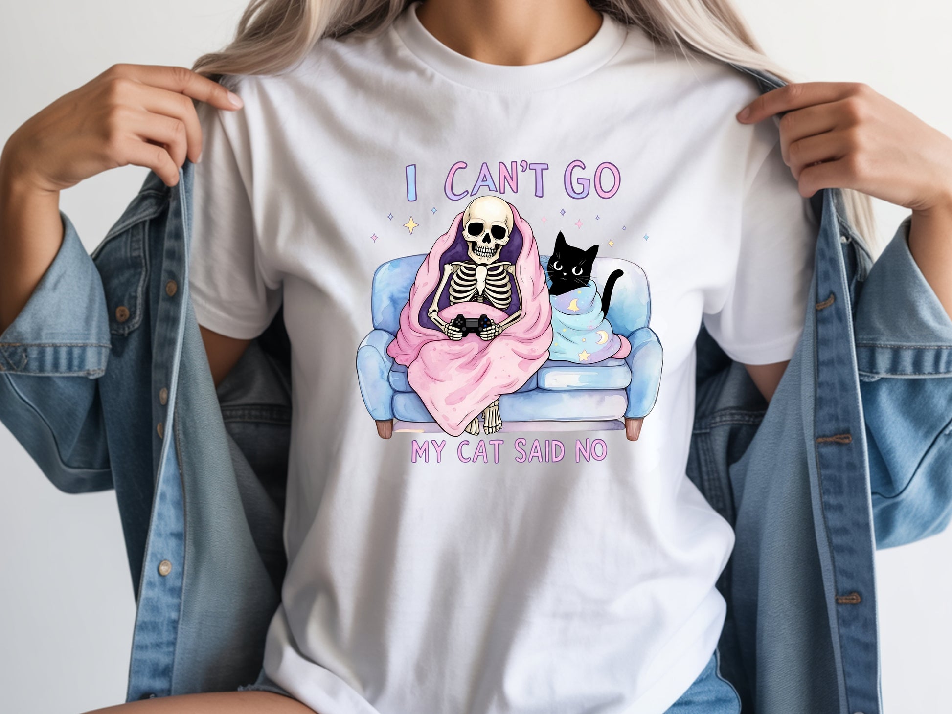 Person wearing white unisex cat lover graphic tee with “I Can’t Go My Cat Said No” quote and skeleton cat design